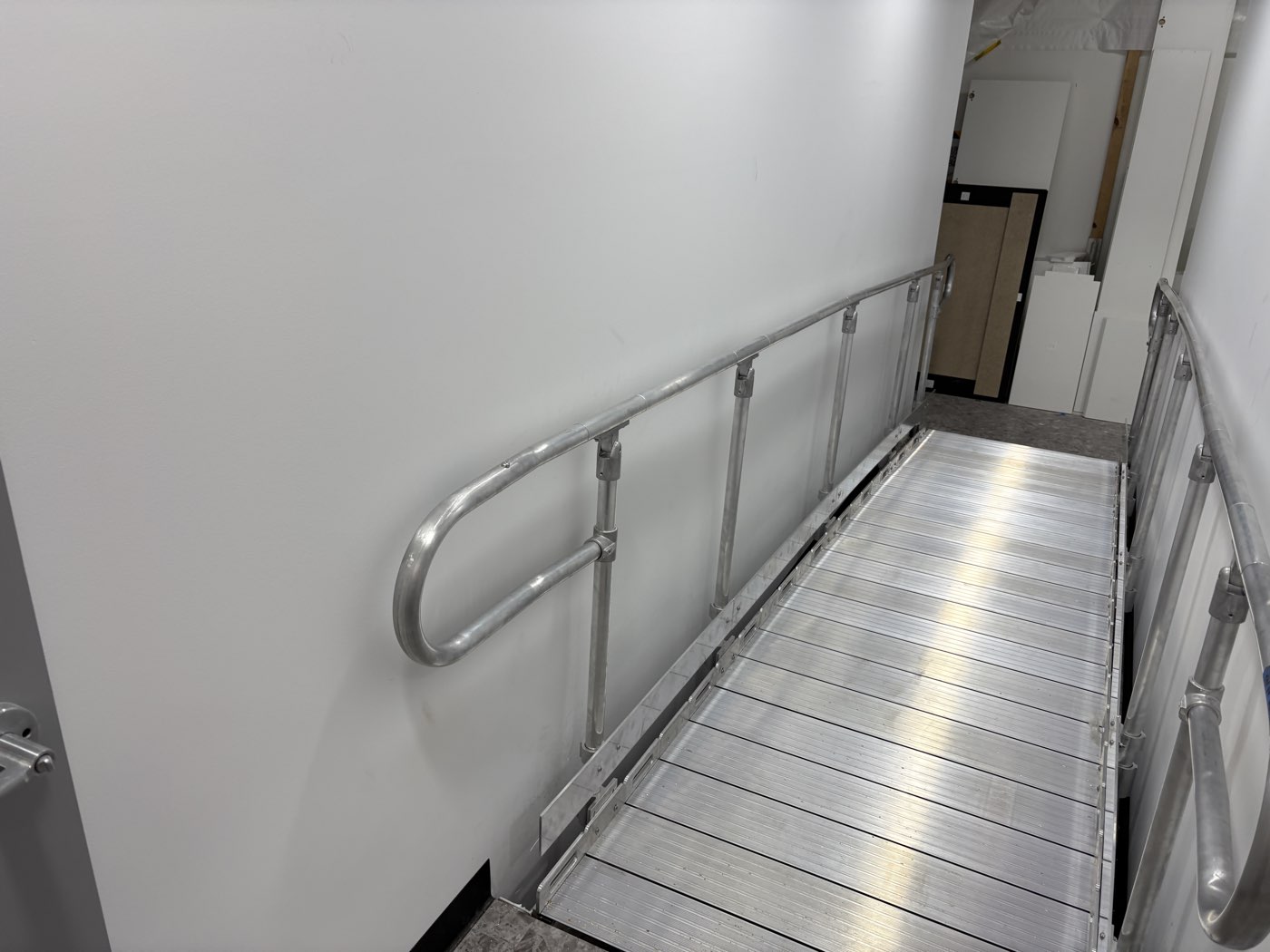 Slip-resistant extruded deck and handrails on a modular aluminium access ramp, on a retail fitout in Rye.